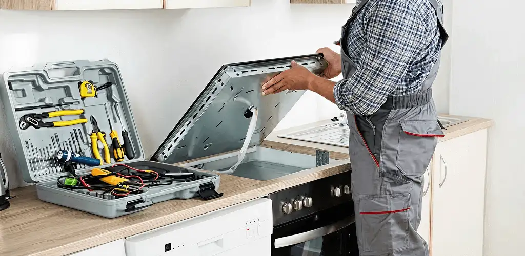 Handyman repairing a cooktop and checking wiring connections in Milwaukee, WI