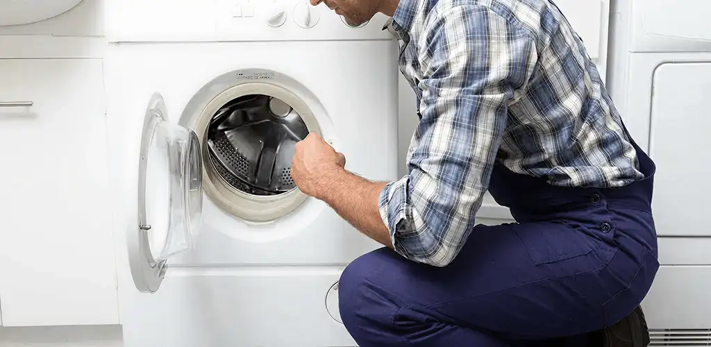 Handyman inspecting a dryer drum and internal parts for repair in Milwaukee, WI