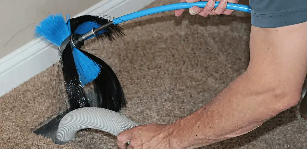 Dryer vent cleaning technician brushing lint from a vent line in Milwaukee, WI