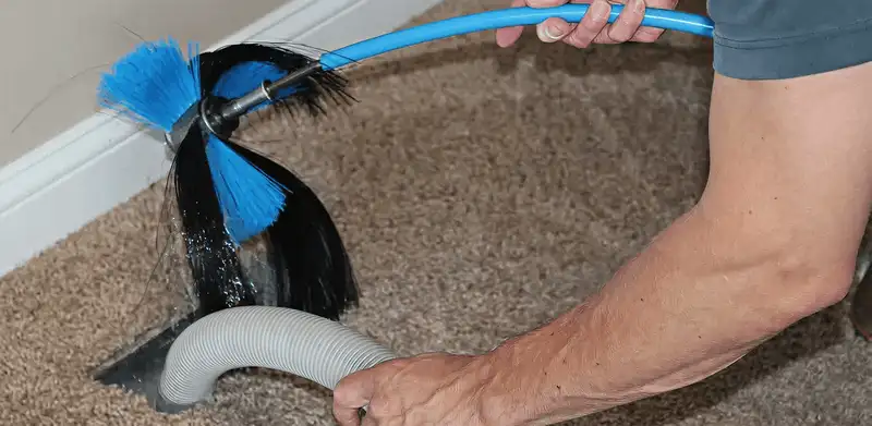 Dryer vent cleaning technician brushing lint from a vent line in Milwaukee, WI