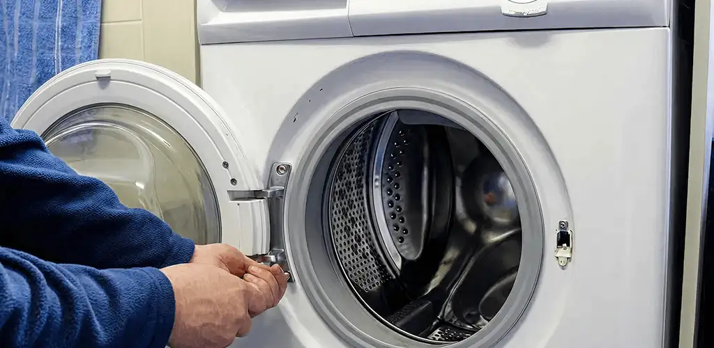 Washing machine repair handyman checking a front-load washer door and latch in Milwaukee, WI
