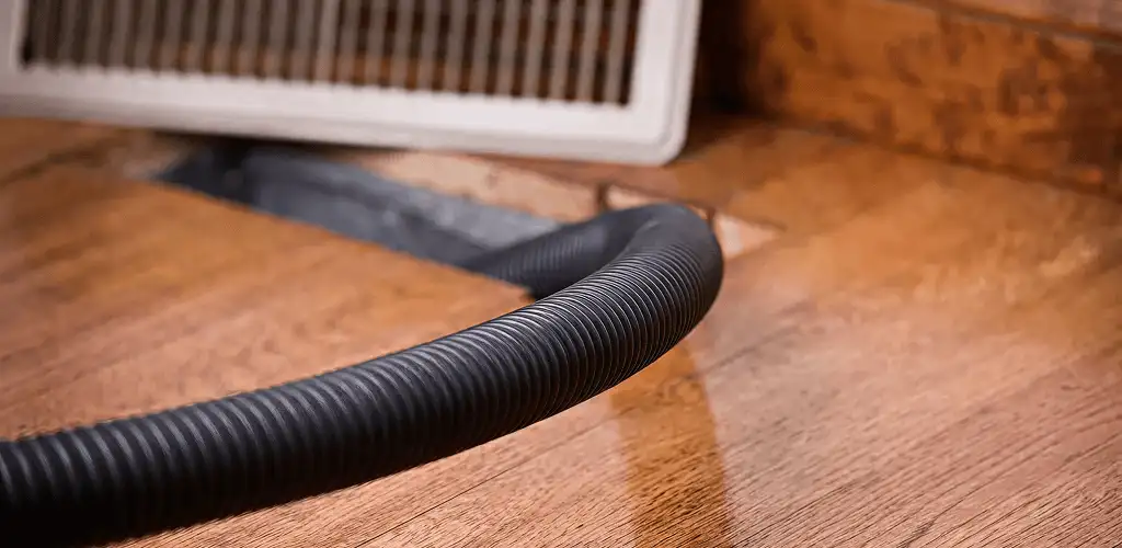 Air duct cleaning hose inserted into a floor vent for ductwork cleaning in Milwaukee, WI