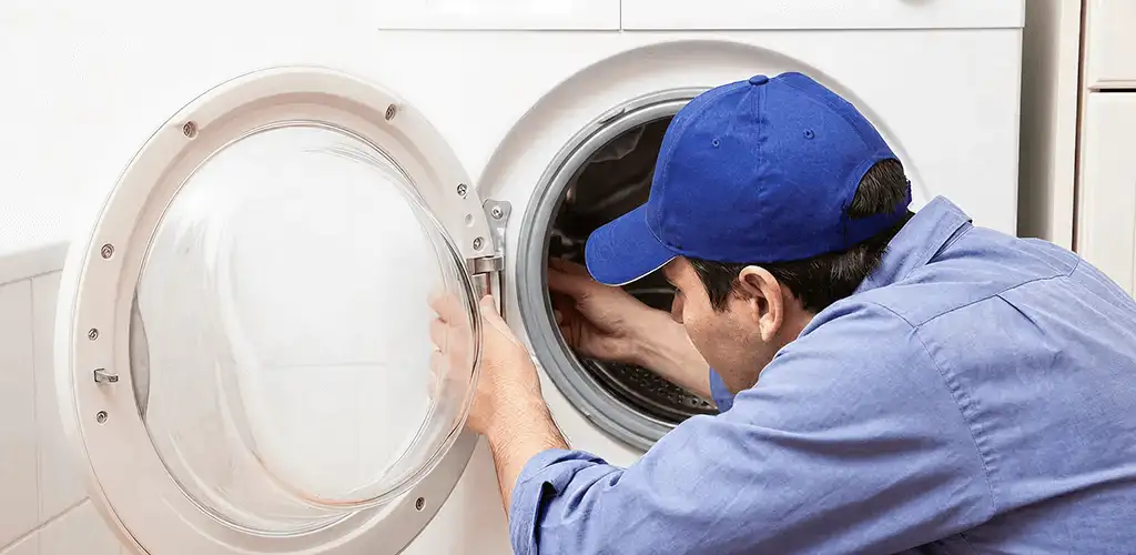 Washing machine repair handyman inspecting a front-load washer drum in Milwaukee, WI