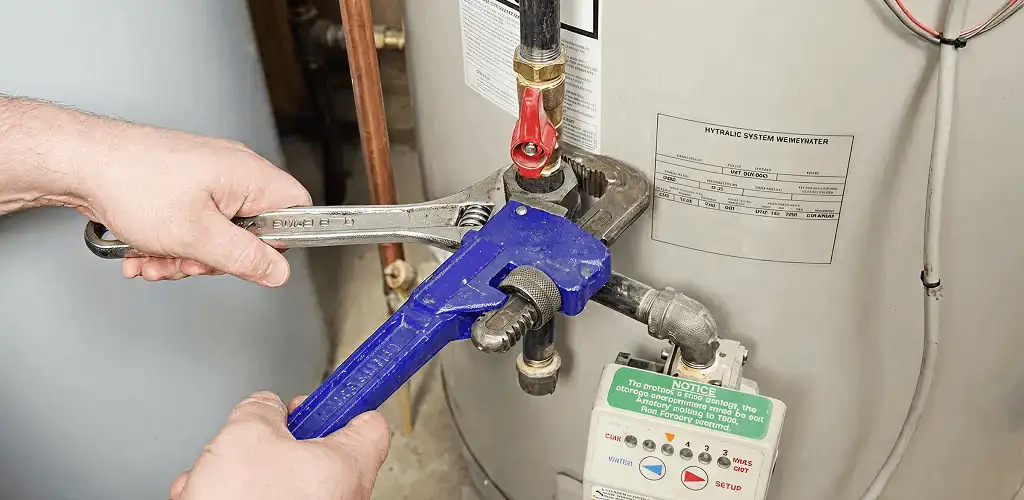 Water heater repair technician tightening the shutoff valve and supply line in Milwaukee, WI